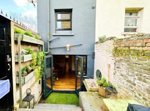 een huis met een hal die leidt naar een patio bij Modern flat with KING bed, garden & outdoor dining in Londen