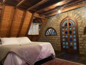 a bedroom with a bed and a stone wall at Tiny Chalet in the clouds in Medellín