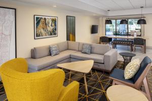 sala de estar con sofá y sillas en Holiday Inn & Suites Boca Raton - North, en Boca Raton