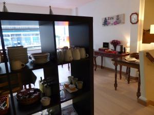 una habitación con una mesa y un estante con tazas en Hotel La Belle Etoile, en Saint-Nazaire