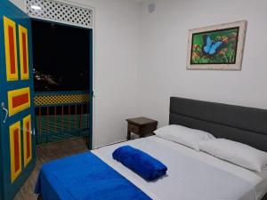 ein Schlafzimmer mit einem Bett mit einem blauen Kissen darauf in der Unterkunft APARTAHOTEL DON BELI in Salento