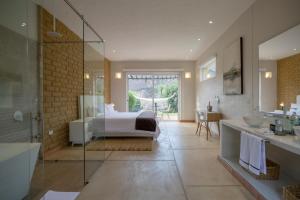 a bedroom with a bed and a bathroom with a shower at Hotel Alma in Villa de Leyva