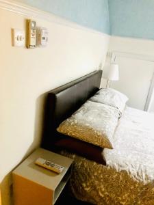 a bedroom with a bed with a table next to it at AC Hideout in Rochford