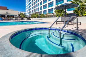 a small swimming pool with an umbrella and an umbrella at Crowne Plaza Hotel Los Angeles Harbor, an IHG Hotel in San Pedro