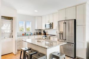 a kitchen with white cabinets and a stainless steel refrigerator at Keys to Happiness in Marathon