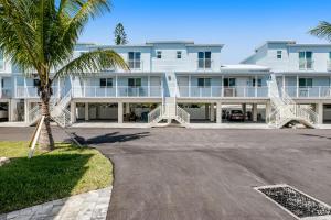 a large white building with a palm tree in front of it at Keys to Happiness in Marathon