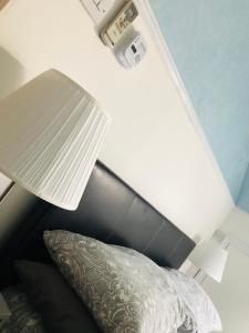 a bedroom with a bed with a lamp and a pillow at AC Hideout in Rochford