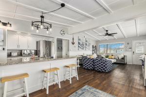 une cuisine et un salon avec des placards blancs et un bar dans l'établissement Sailboat House, à Surfside Beach