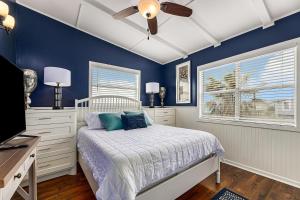 - une chambre bleue avec un lit et un ventilateur de plafond dans l'établissement Sailboat House, à Surfside Beach