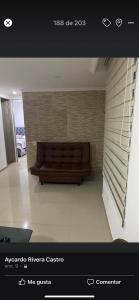 un divano marrone in una stanza con parete di Apartamento villavicencio a Villavicencio