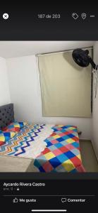a bedroom with a bed with a colorful quilt at Apartamento villavicencio in Villavicencio
