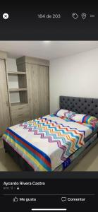 una camera da letto con un letto con un piumone colorato di Apartamento villavicencio a Villavicencio