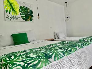 a bedroom with a bed with a green and white comforter at Freddy`s Place B&B in Monteverde Costa Rica