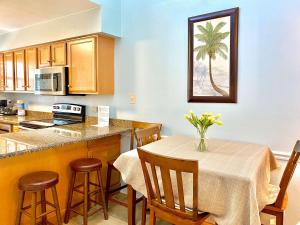 a kitchen and dining room with a table and chairs at Lani Kai Village 211 by ALBVR - Beautifully Remodeled Condo with Indirect Gulf views from Balcony! in Gulf Shores