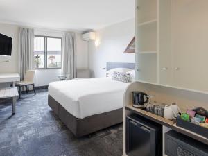 a hotel room with a bed and a desk at JetPark Auckland Airport Hotel in Auckland