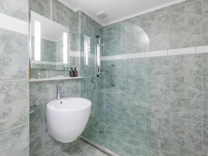 a bathroom with a white sink and a shower at JetPark Auckland Airport Hotel in Auckland