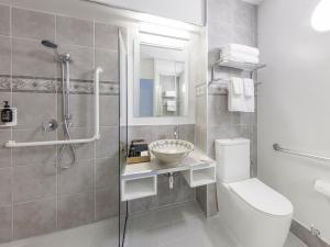 a bathroom with a toilet and a sink and a shower at JetPark Auckland Airport Hotel in Auckland