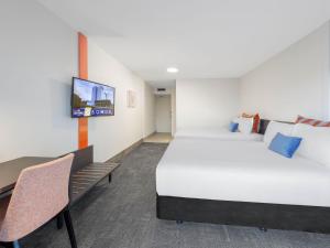 a hotel room with two beds and a tv at JetPark Auckland Airport Hotel in Auckland