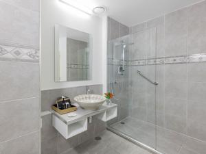 a bathroom with a sink and a glass shower at JetPark Auckland Airport Hotel in Auckland