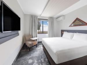 a hotel room with a bed and a television at JetPark Auckland Airport Hotel in Auckland
