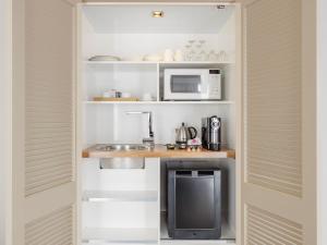 a small kitchen with a sink and a microwave at JetPark Auckland Airport Hotel in Auckland