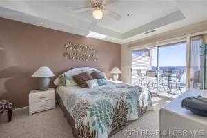 a bedroom with a bed and a balcony with a view at Rare GEM @Emerald Bay - Smart Home - THAT VIEW!!! in Lake Ozark +57 photos