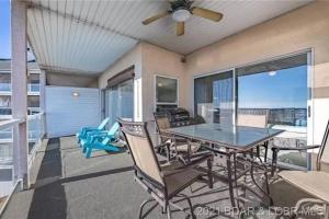 a dining room with a table and chairs on a balcony at Rare GEM @Emerald Bay - Smart Home - THAT VIEW!!! in Lake Ozark