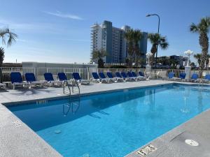 a swimming pool with blue chairs and a building at Grand Caribbean 419 by ALBVR - New Owner - Great location in Orange Beach
