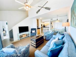 ein Wohnzimmer mit einem blauen Sofa und einem TV in der Unterkunft Sugar Beach 321 by ALBVR - Beautiful condo at the beach from ALBVR! in Gulf Shores