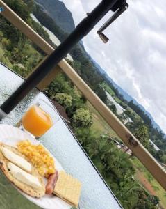 a plate of breakfast food on a table with a view at Alto Paraíso Glamping Carmen de Viboral in Rionegro