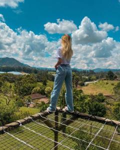 a young girl standing on top of a fence at Alto Paraíso Glamping Carmen de Viboral in Rionegro