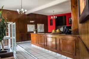 cocina con paredes rojas y encimera de madera en Hotel Jorges Morelia, en Morelia
