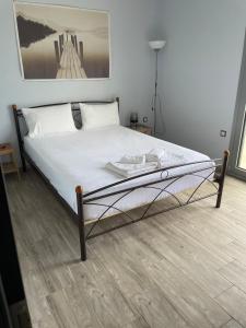 sypialnia z łóżkiem z białą pościelą i obrazem w obiekcie Ambelakia Bungalow w mieście Monemwasia