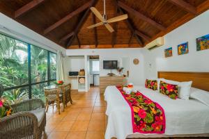 1 dormitorio con 1 cama y sala de estar en The Cooks Oasis en Rarotonga