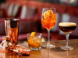 three different types of drinks on a wooden table at JetPark Auckland Airport Hotel in Auckland
