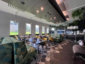 - une salle à manger avec des tables, des chaises et des fenêtres dans l'établissement JetPark Auckland Airport Hotel, à Auckland