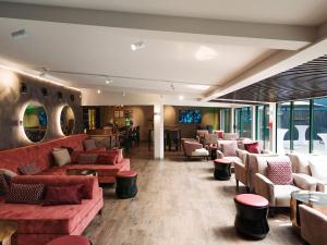 a lobby with couches and chairs and a bar at JetPark Auckland Airport Hotel in Auckland