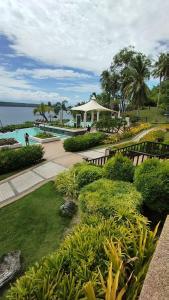 un jardin avec une piscine et une maison dans l'établissement Kembali CONDO Resort with Sea View, à Davao