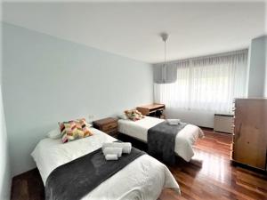 una habitación de hotel con 2 camas en una habitación en playa Santa Cristina, en Oleiros