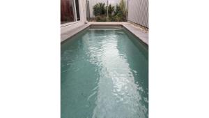 a swimming pool with blue water in a house at Sea Poppy in Casuarina +26 photos