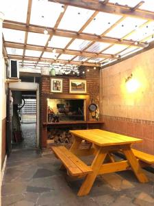 a picnic table and bench in a room with a brick wall at Apartamento independiente en alquiler En casa de familia in Montevideo