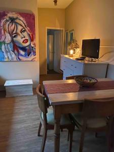 a dining room with a table and a painting on the wall at Apartamento independiente en alquiler En casa de familia in Montevideo