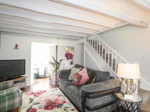 a living room with a couch and a television at Bryn Peris in Moelfre