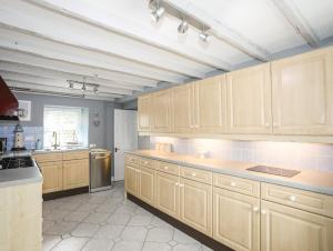 a kitchen with wooden cabinets and a counter top at Bryn Peris in Moelfre