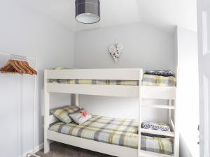 a bedroom with two bunk beds in a room at Bryn Peris in Moelfre
