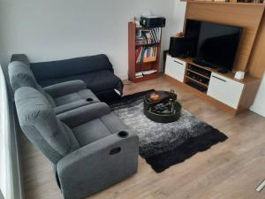 a living room with a couch and a television at Acogedora Casa Comoda y Tranquila a 5 min del Turi in Cuenca