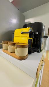 a kitchen shelf with three bowls and a toaster at Beyond Zurich HOME Staycation in Manila