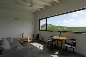 uma sala de estar com uma mesa e cadeiras e uma grande janela em Solar Branco Eco Estate em Ponta Delgada