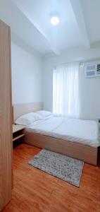 um quarto com uma cama, uma janela e um tapete em SCANDIA SUITES AT SOUTH FORBES Homey & Cozy 2-Bedroom Condo em Silang