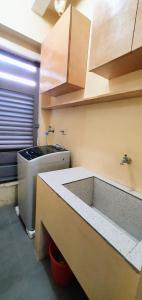 - une cuisine avec un évier et un comptoir dans l'établissement SCANDIA SUITES AT SOUTH FORBES Homey & Cozy 2-Bedroom Condo, à Silang